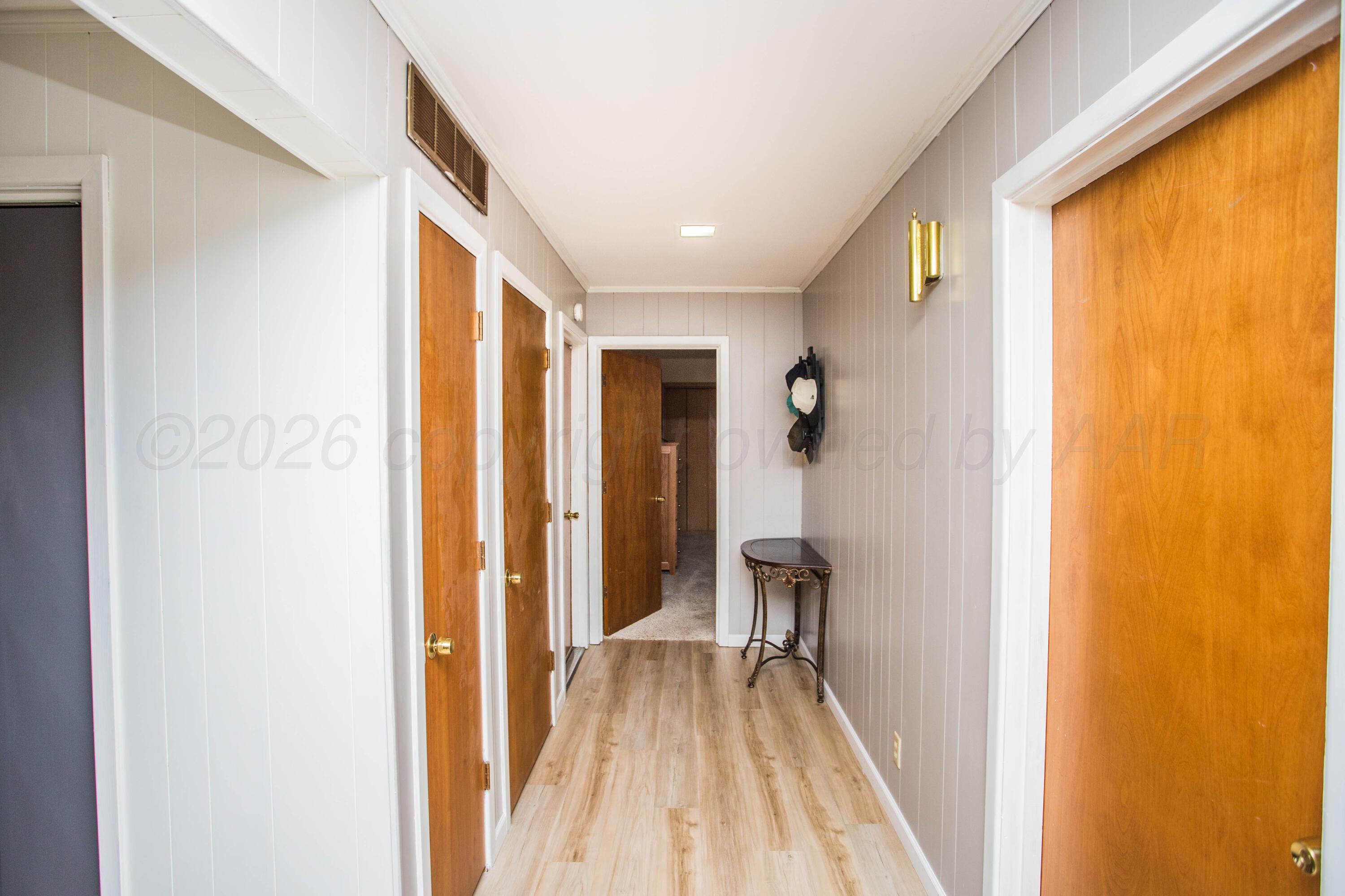 73 Houston Road Tulia, TX 79088 - Photo 21 of 55 a view of a hallway with wooden floor and a bathroom