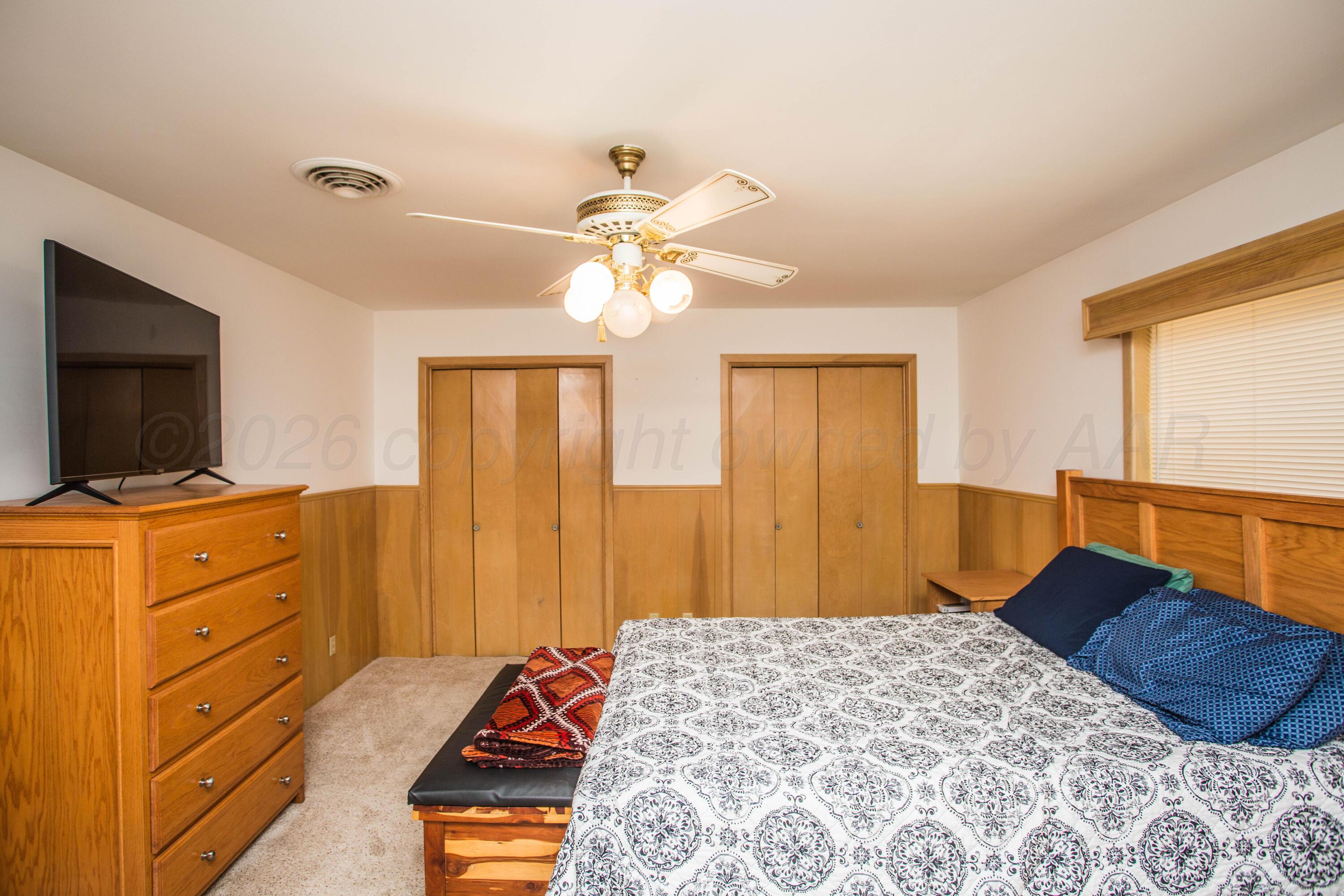 73 Houston Road Tulia, TX 79088 - Photo 26 of 55 a bedroom with a bed and a flat tv screen on dresser