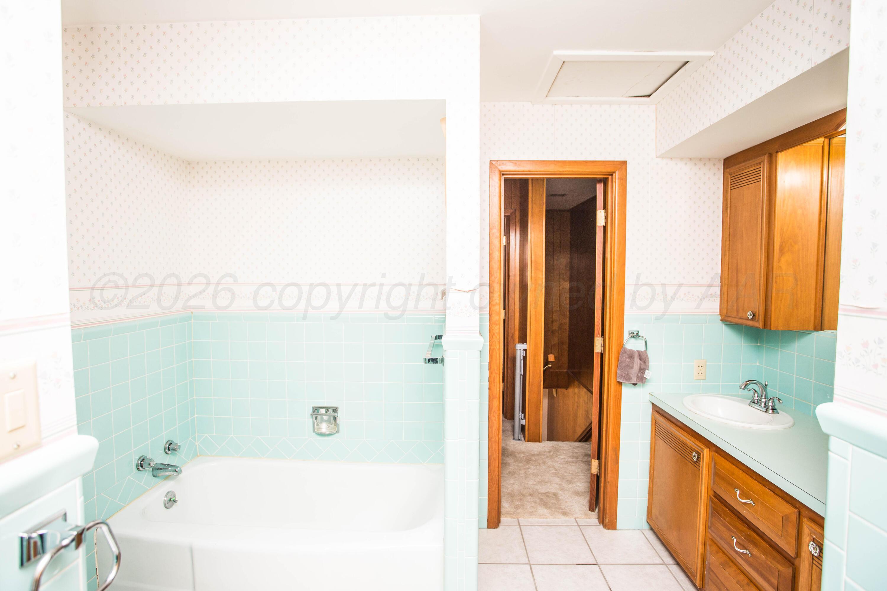 73 Houston Road Tulia, TX 79088 - Photo 47 of 55 a bathroom with a sink a mirror and a bathtub