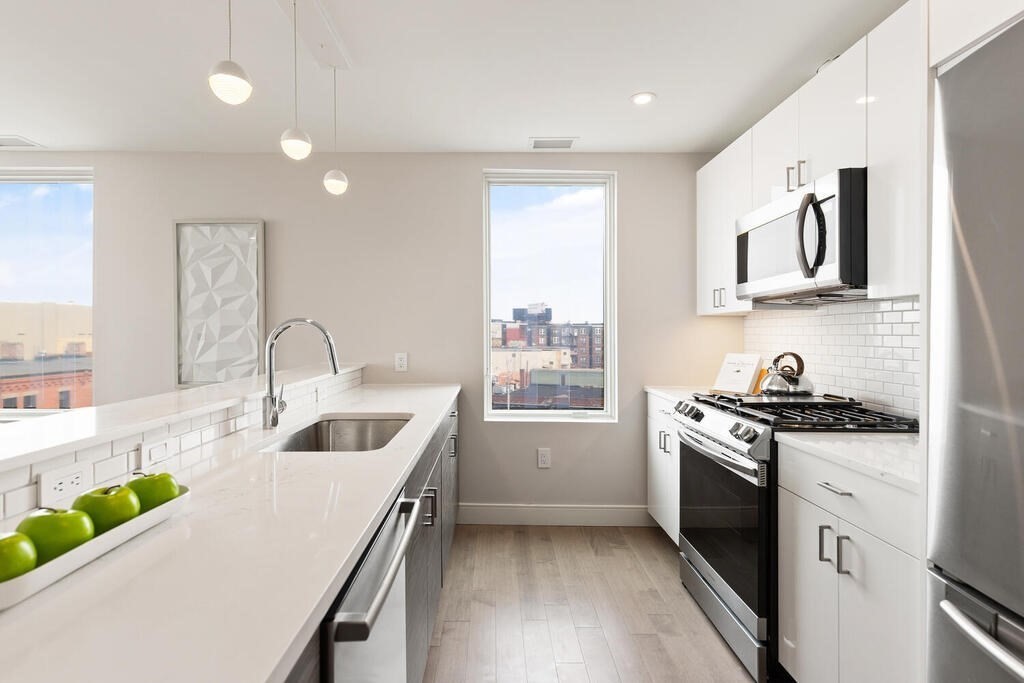 398 Cambridge Street, Unit 502 Boston, MA 02134 - Photo 4 of 11 a kitchen that has a sink a stove and window