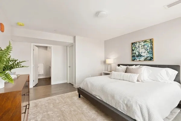 a bedroom with a bed table and a window