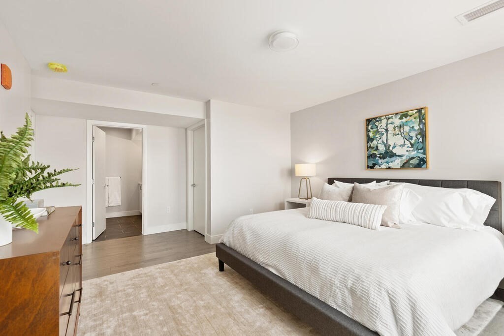 398 Cambridge Street, Unit 502 Boston, MA 02134 - Photo 5 of 11 a bedroom with a bed and a painting on the wall
