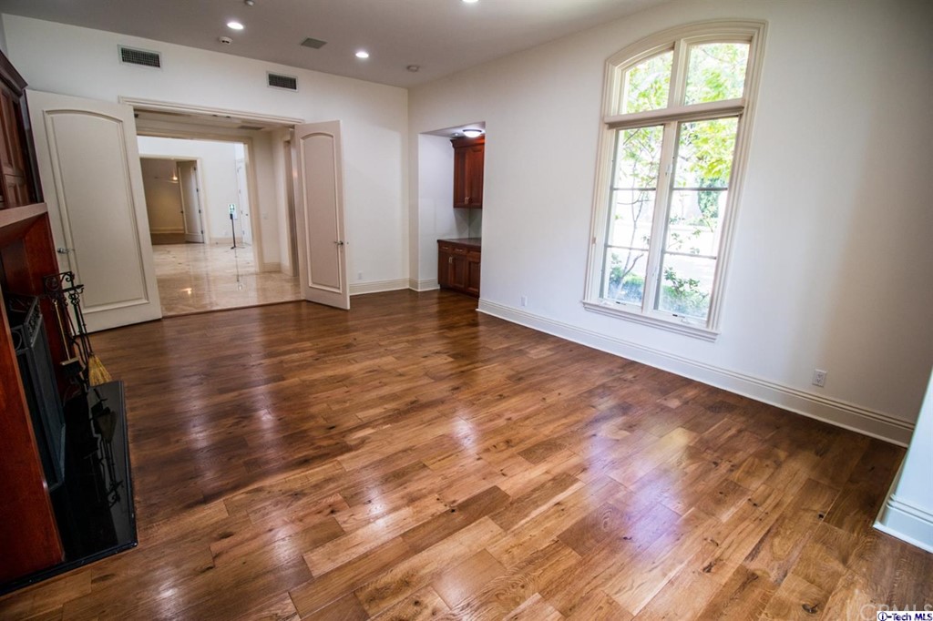 12801 Chalon Road Los Angeles, CA 90049 - Photo 15 of 77 an empty room with wooden floor and windows
