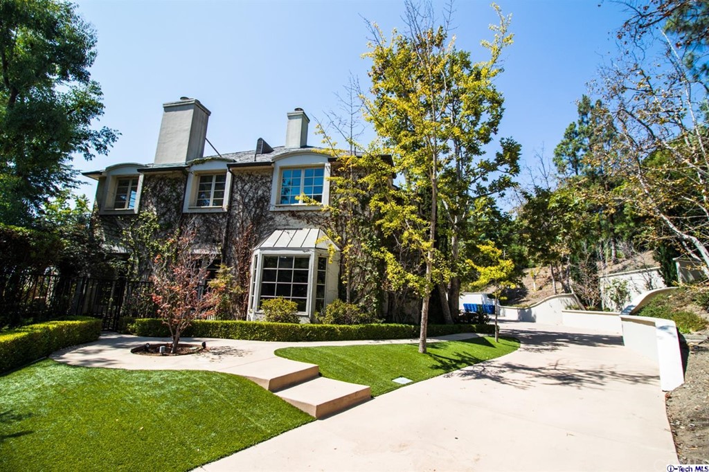 12801 Chalon Road Los Angeles, CA 90049 - Photo 2 of 77 a front view of a house with garden and trees