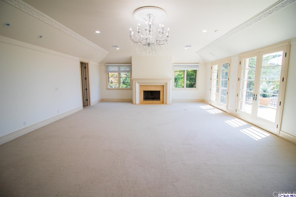 12801 Chalon Road Los Angeles, CA 90049 - Photo 35 of 77 a view of a livingroom with a fireplace a chandelier and a large window