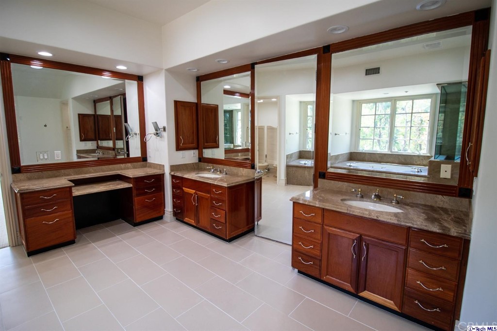 12801 Chalon Road Los Angeles, CA 90049 - Photo 36 of 77 a large kitchen with stainless steel appliances granite countertop a stove and a sink