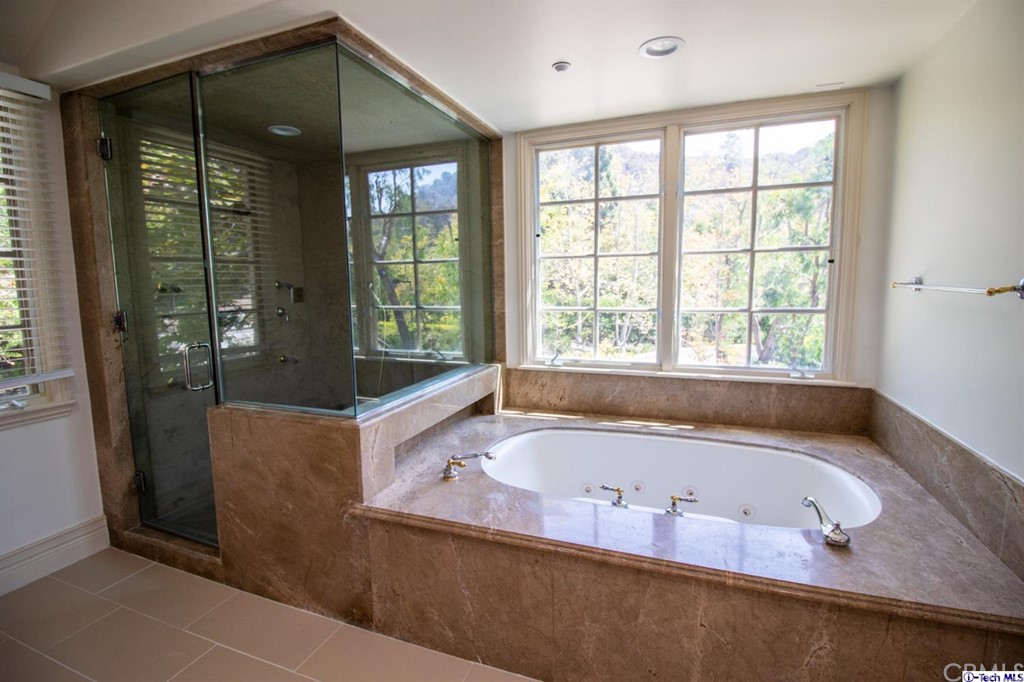 12801 Chalon Road Los Angeles, CA 90049 - Photo 37 of 77 a bath tub sitting in a bathroom next to a window