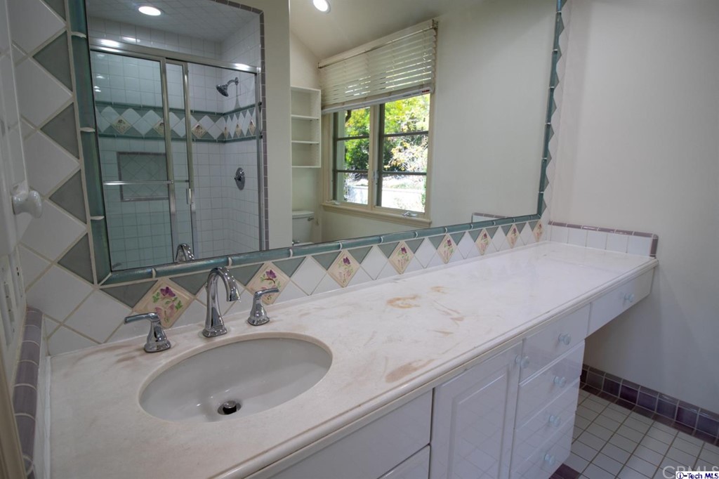 12801 Chalon Road Los Angeles, CA 90049 - Photo 48 of 77 a bathroom with a sink and a mirror