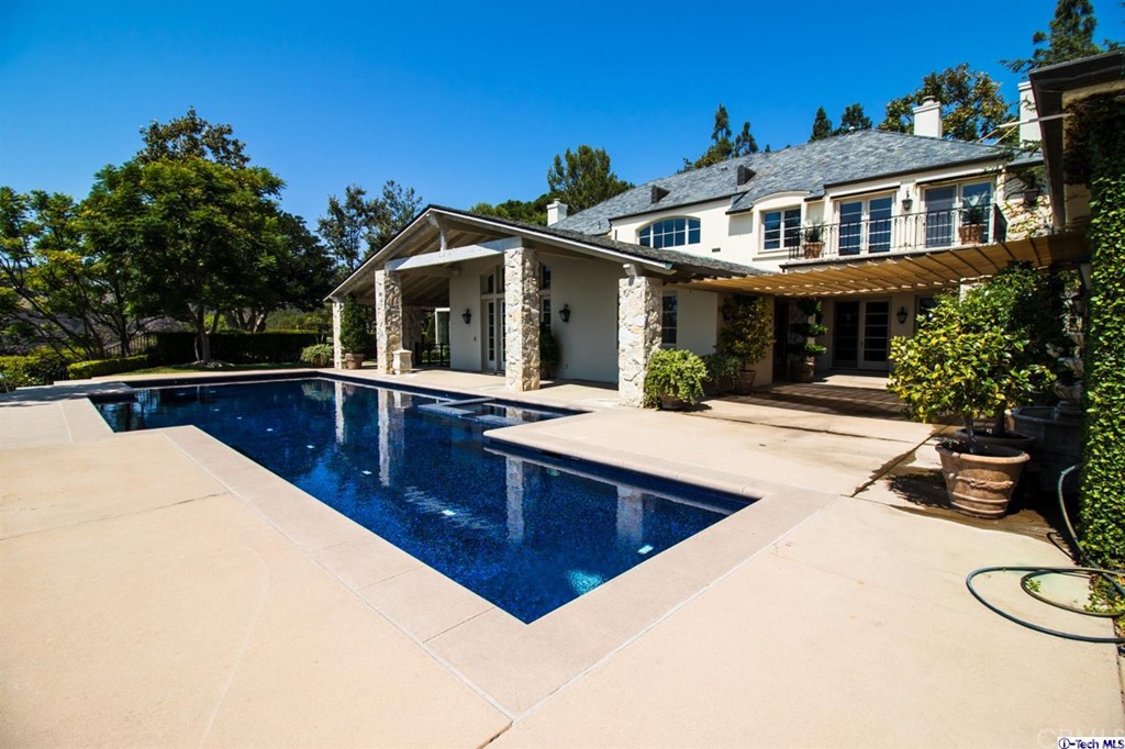 12801 Chalon Road Los Angeles, CA 90049 - Photo 61 of 77 a view of a white house with large windows and a table and chairs