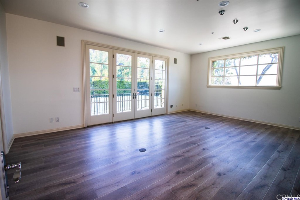 12801 Chalon Road Los Angeles, CA 90049 - Photo 64 of 77 an empty room with wooden floor and windows