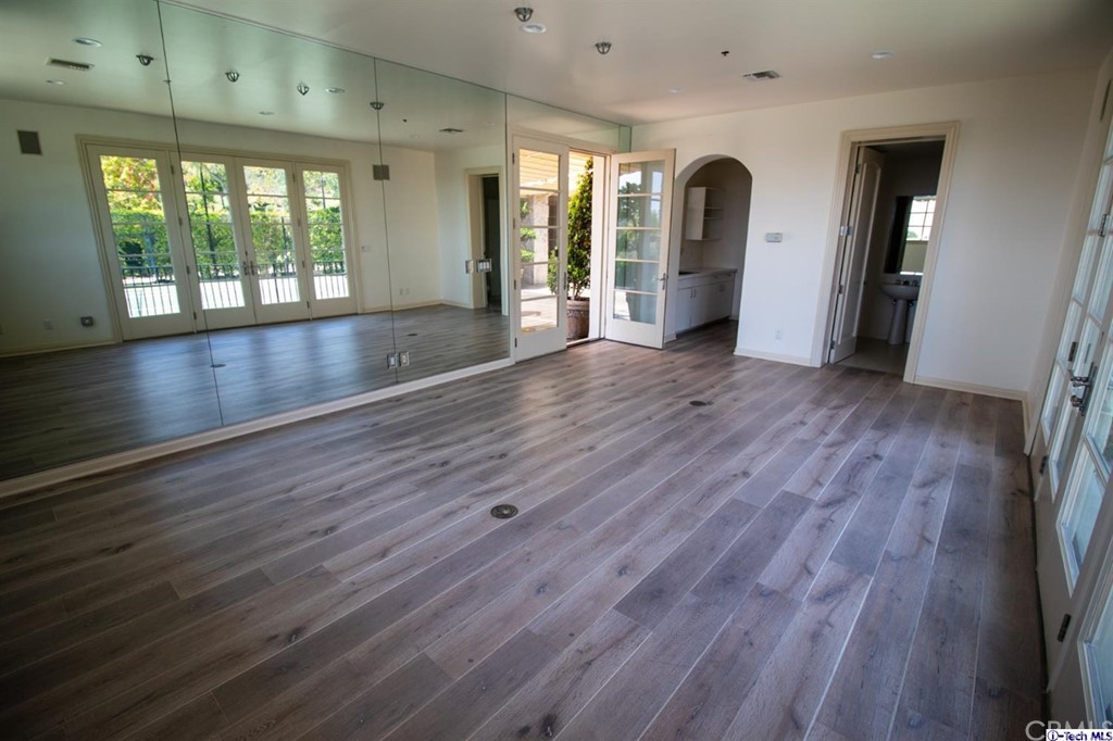 12801 Chalon Road Los Angeles, CA 90049 - Photo 65 of 77 an empty room with wooden floor and windows