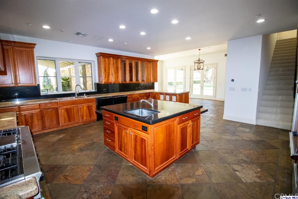 12801 Chalon Road Los Angeles, CA 90049 - Photo 8 of 77 a kitchen with stainless steel appliances granite countertop a sink and a stove