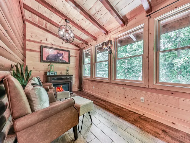 a living room with furniture a flat screen tv and a large window