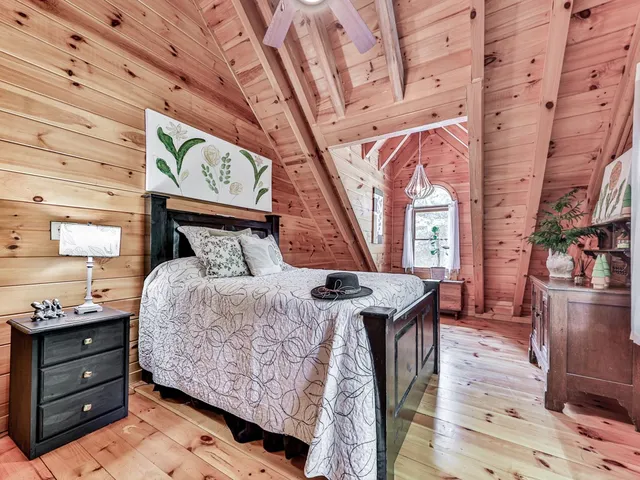 a bedroom with a bed and a dresser next to a window