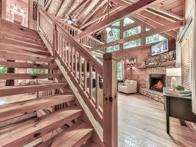 a view of staircase with furniture and a fireplace