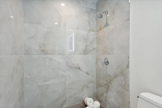 a view of kitchen with stainless steel appliances wooden floor and window