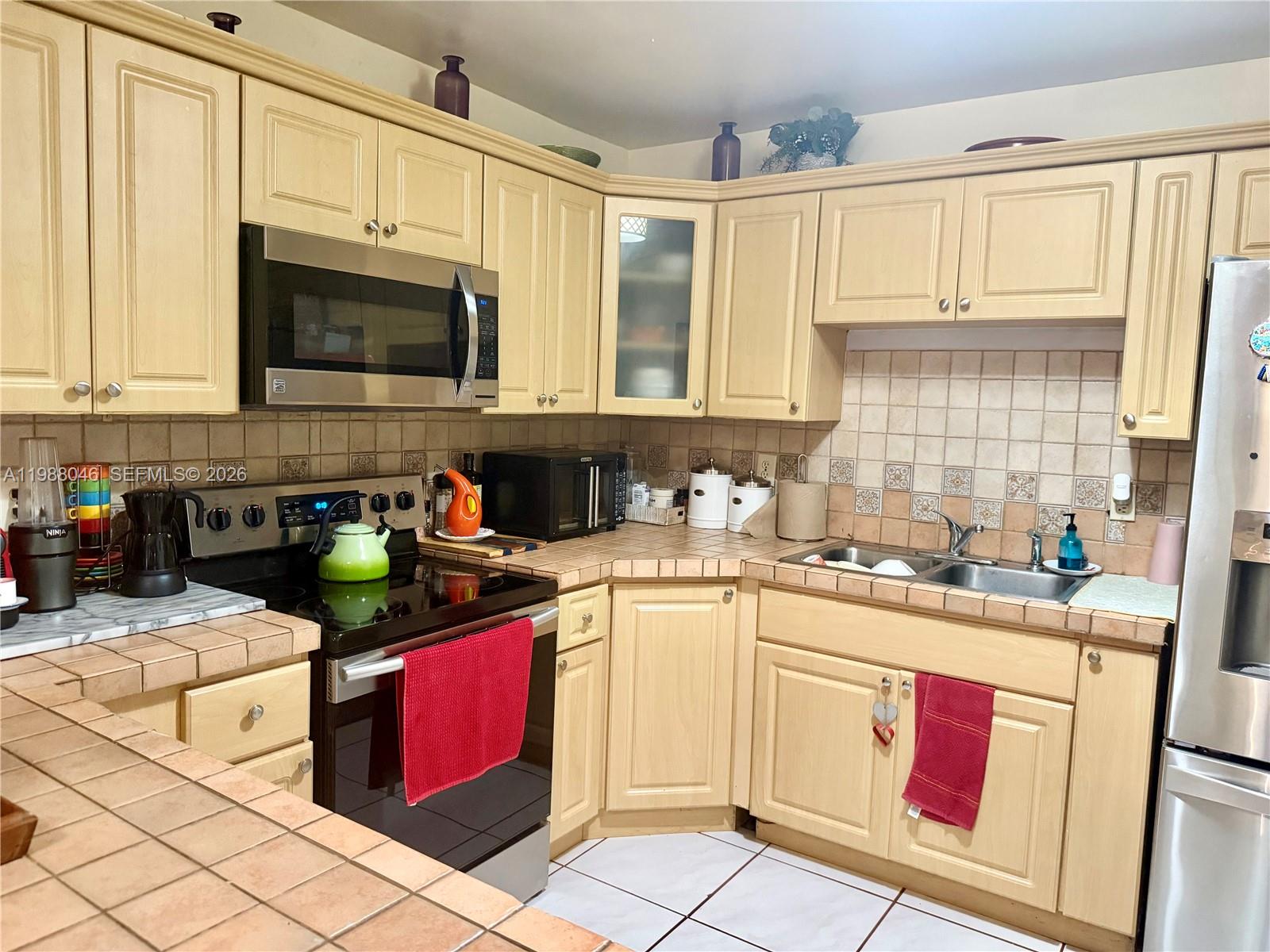14474 Southwest 293rd Terrace Homestead, FL 33033 - Photo 7 of 20 a kitchen with stainless steel appliances granite countertop a stove sink microwave and cabinets