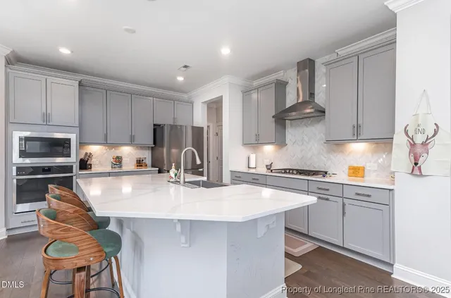 a kitchen with stainless steel appliances granite countertop a table chairs sink refrigerator and cabinets