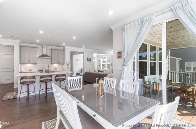a kitchen with stainless steel appliances granite countertop a dining table chairs and granite counter tops