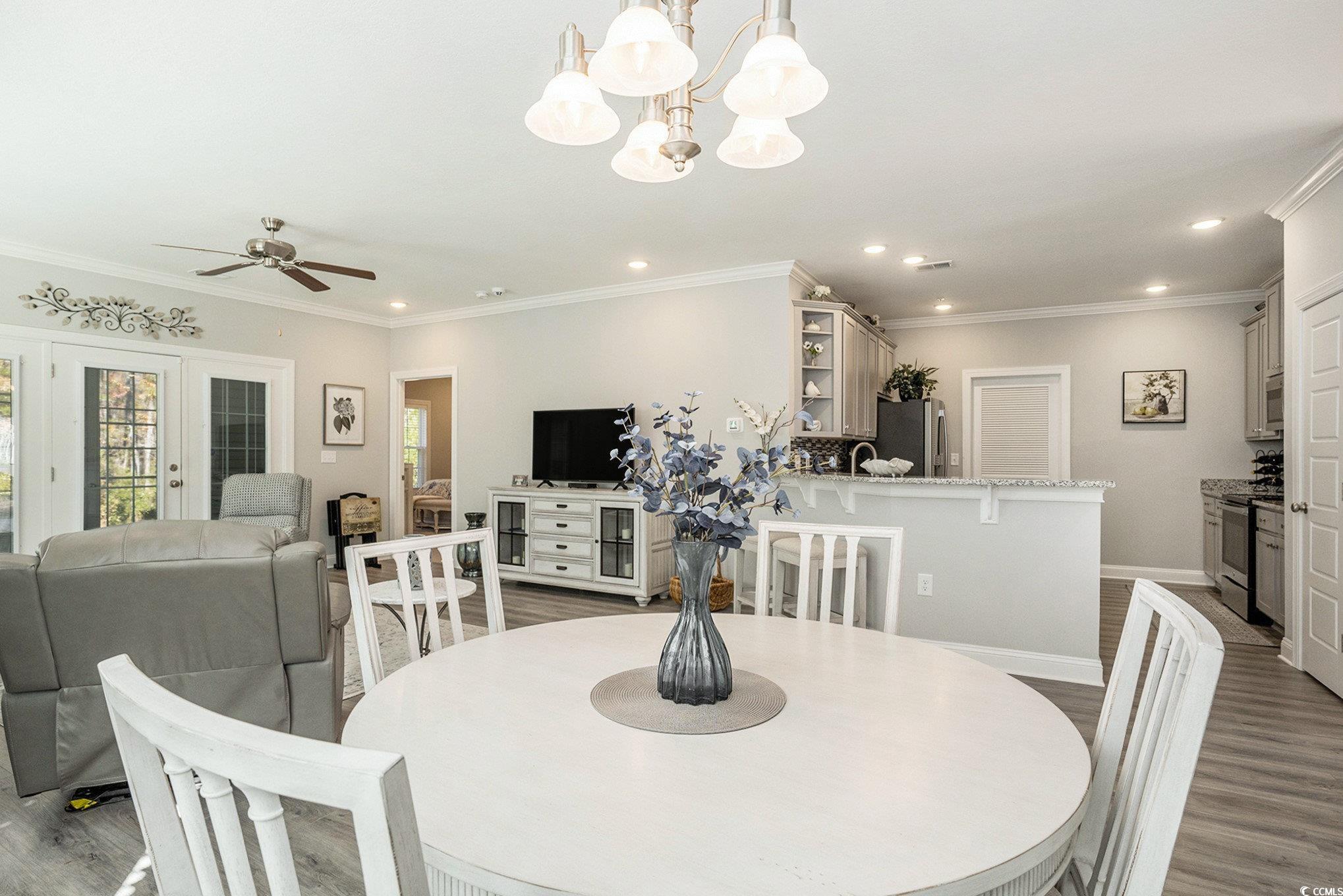 932 Jackline Place, Unit 101 Murrells Inlet, SC 29576 - Photo 13 of 40 Dining area featuring dark wood-type flooring, crown molding, a ceiling fan, recessed lighting, and a chandelier