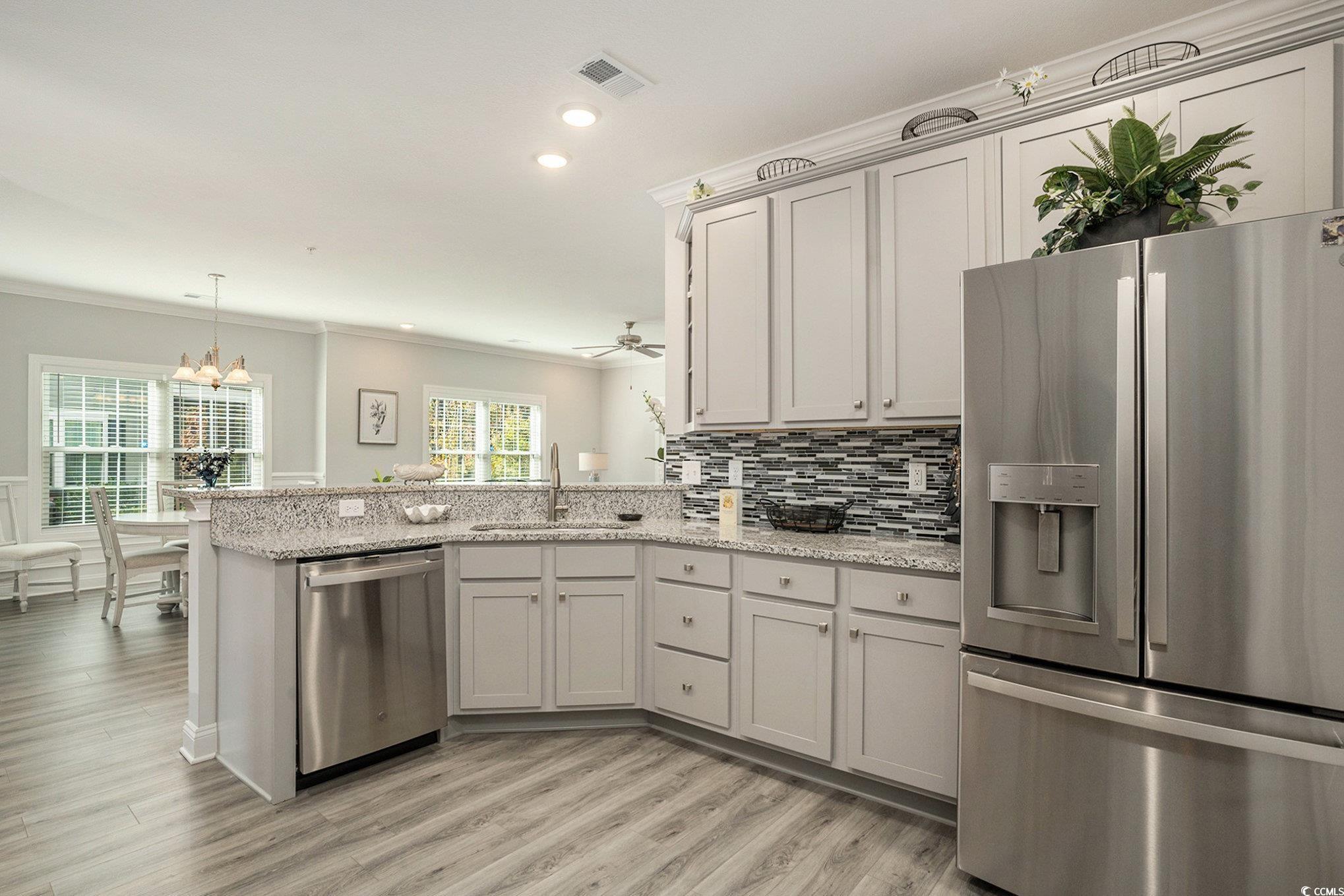 932 Jackline Place, Unit 101 Murrells Inlet, SC 29576 - Photo 17 of 40 Kitchen with stainless steel appliances, ornamental molding, a peninsula, light stone counters, and decorative backsplash