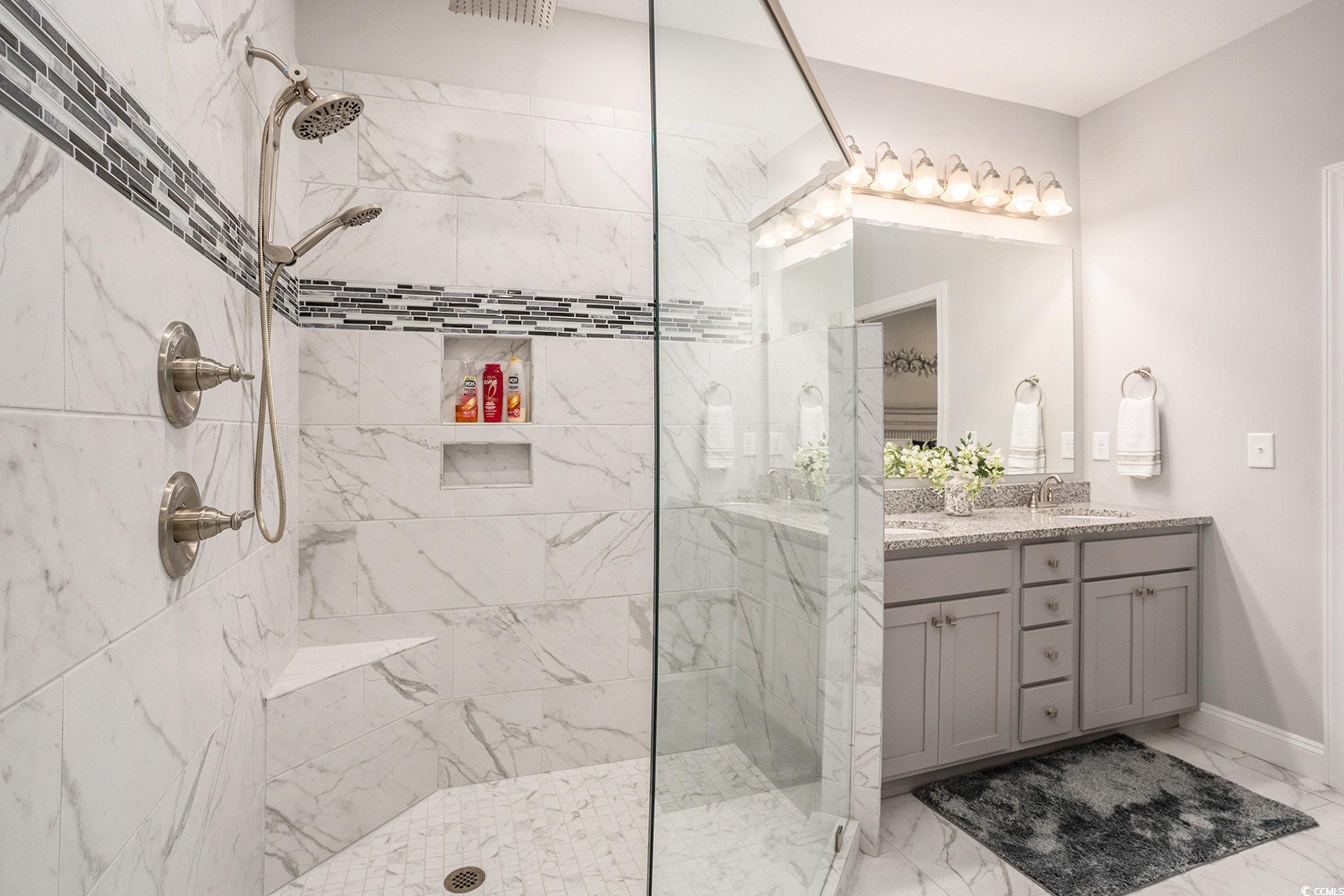 932 Jackline Place, Unit 101 Murrells Inlet, SC 29576 - Photo 20 of 40 Full bathroom with double vanity, a marble finish shower, and light marble finish floors