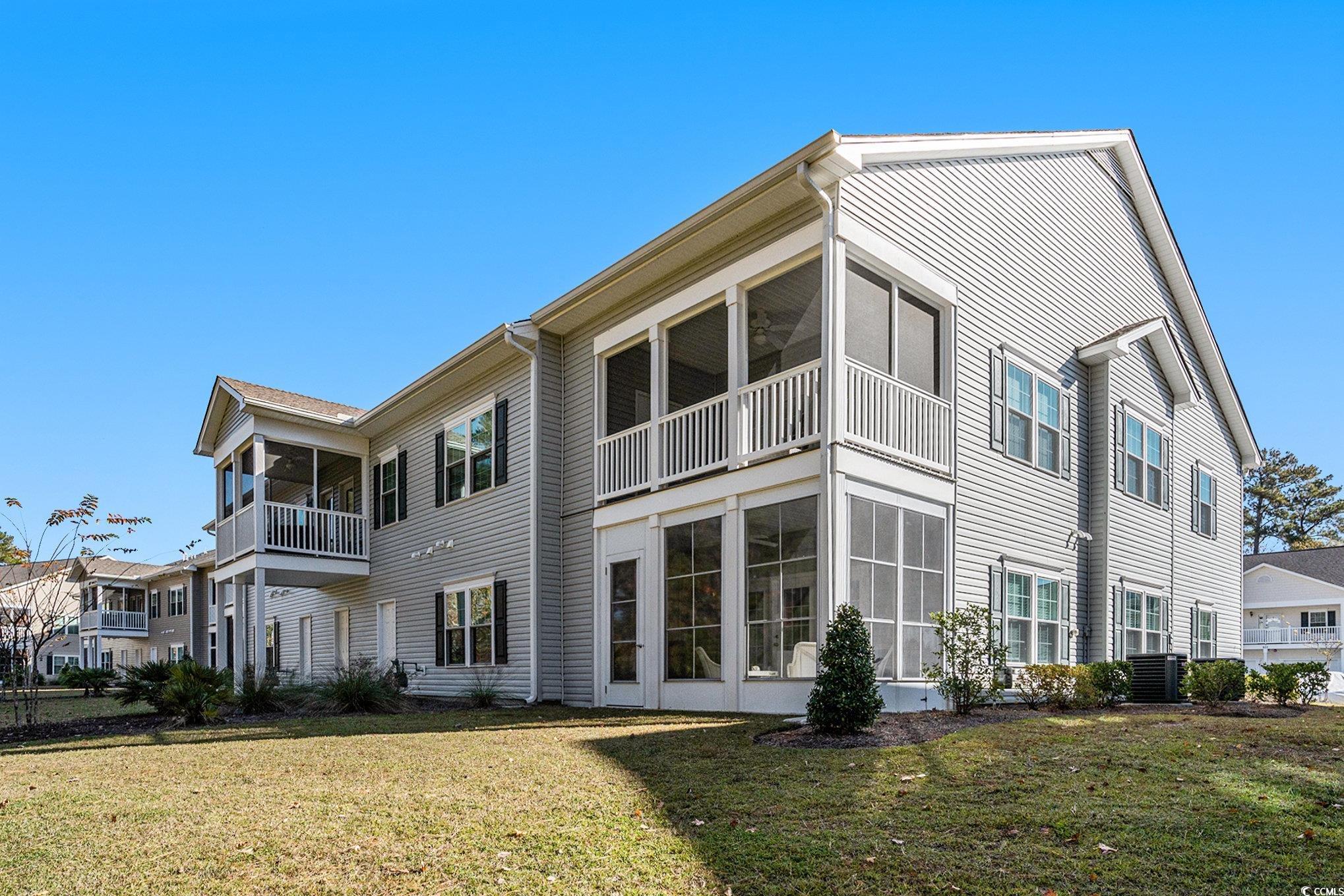 932 Jackline Place, Unit 101 Murrells Inlet, SC 29576 - Photo 35 of 40 Rear view of house with a sunroom, a yard, and a balcony