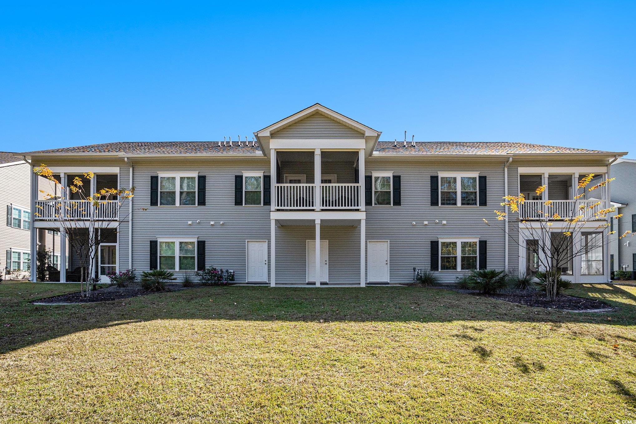 932 Jackline Place, Unit 101 Murrells Inlet, SC 29576 - Photo 36 of 40 Back of property featuring a lawn, a balcony, and a sunroom