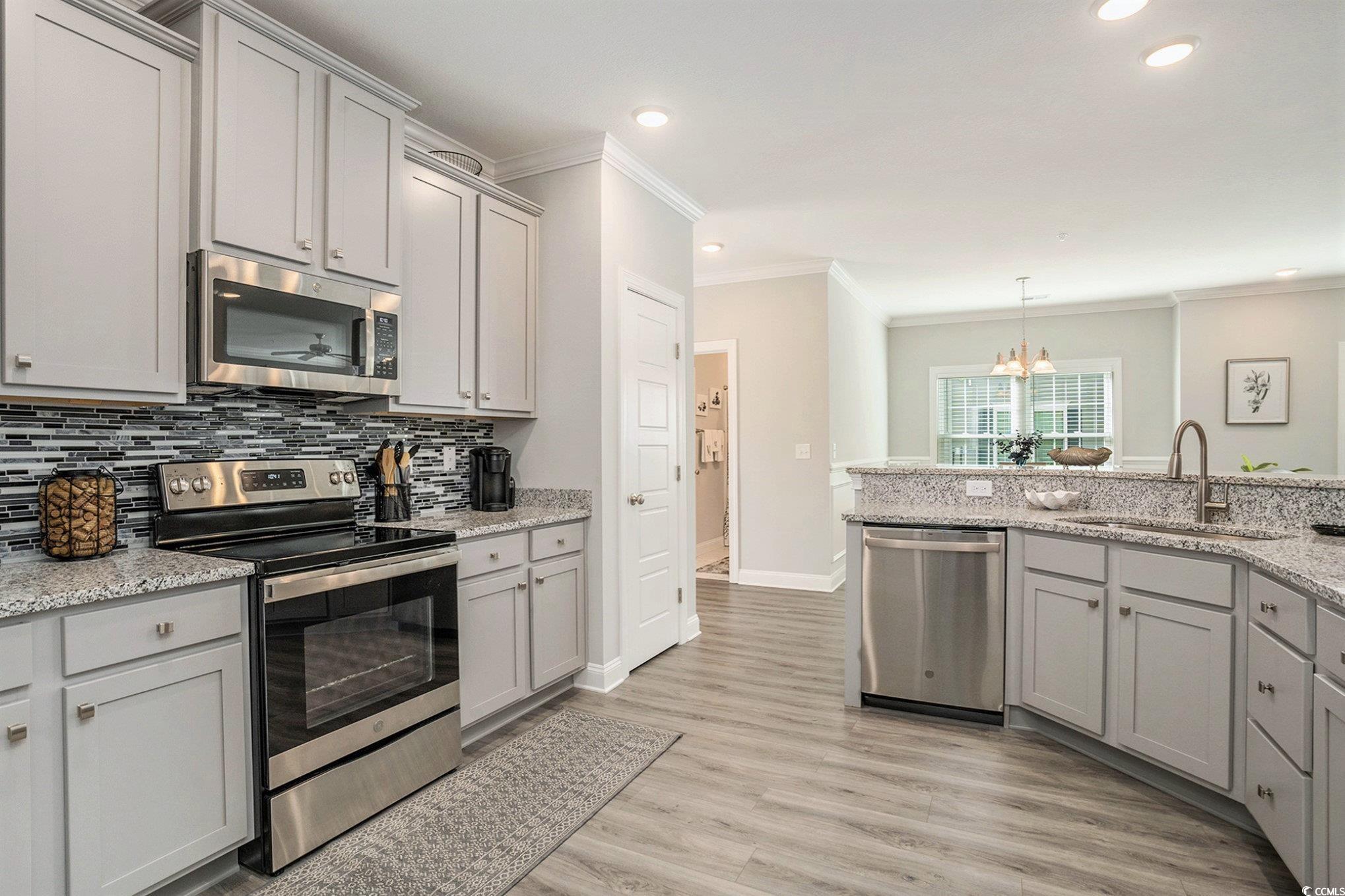 932 Jackline Place, Unit 101 Murrells Inlet, SC 29576 - Photo 5 of 40 Kitchen featuring gray cabinets, appliances with stainless steel finishes, light stone countertops, a chandelier, and pendant lighting