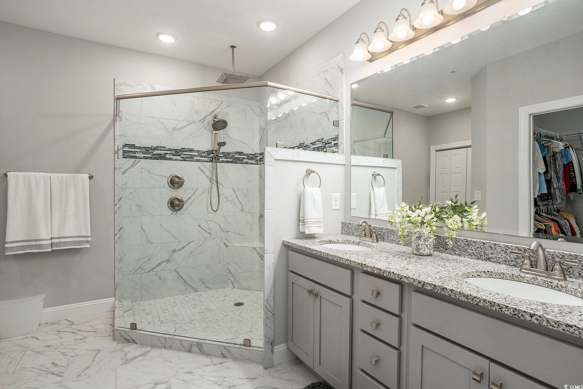 932 Jackline Place, Unit 101 Murrells Inlet, SC 29576 - Photo 7 of 40 Bathroom featuring double vanity, light marble finish flooring, a spacious closet, a marble finish shower, and recessed lighting