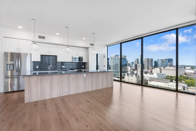 a kitchen with stainless steel appliances granite countertop a refrigerator a sink and a stove