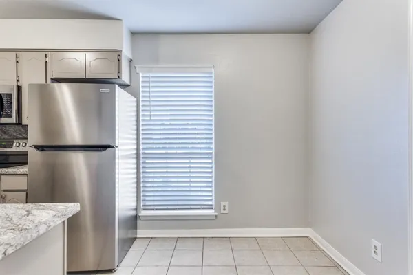 a view of kitchen with a refrigerator cabinets and a window