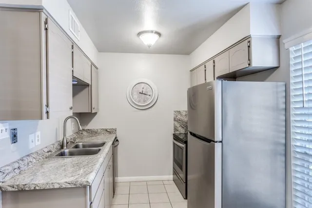 a kitchen with stainless steel appliances granite countertop a refrigerator and a sink