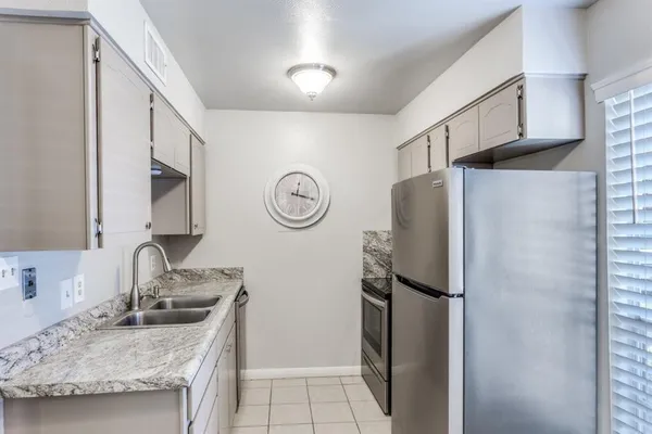 a kitchen with stainless steel appliances granite countertop a refrigerator and a sink