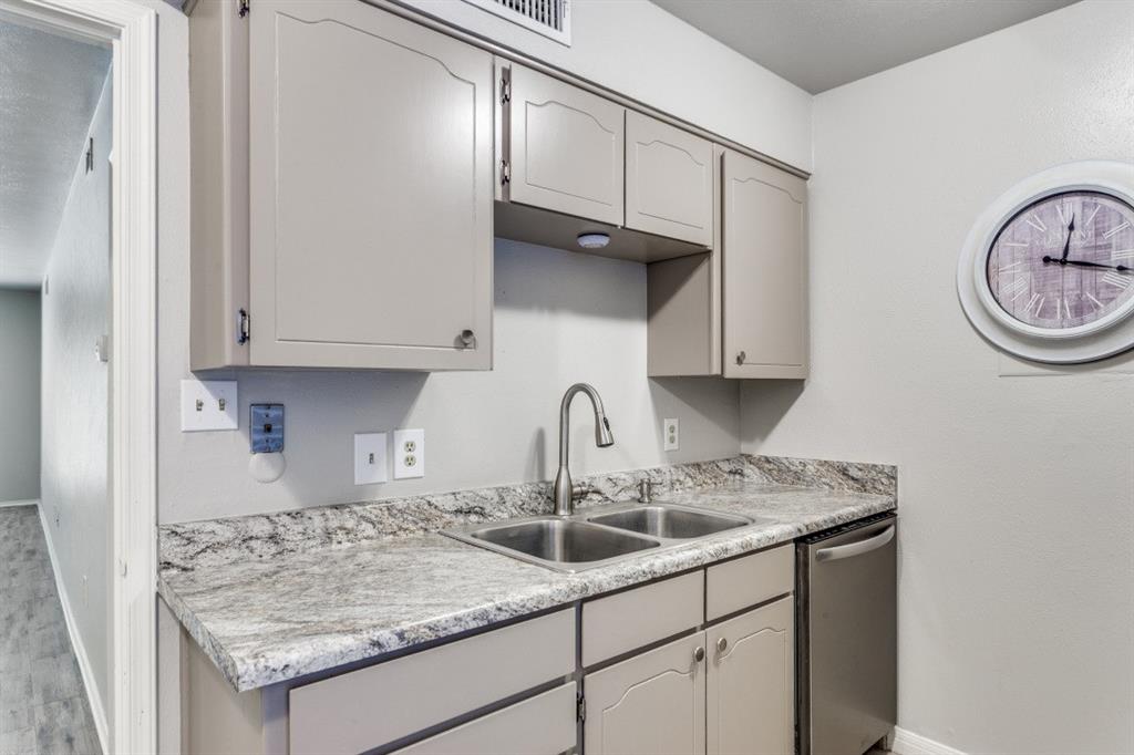 4022 Ridglea Country Club Drive, Unit 608 Fort Worth, TX 76126 - Photo 14 of 28 a kitchen with granite countertop a sink a stove and cabinets
