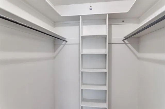 a view of walk in closet with empty racks