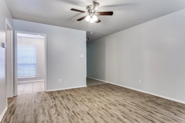 a view of a room with wooden floor and a ceiling fan