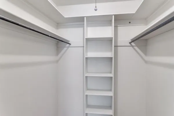 a view of walk in closet with empty racks
