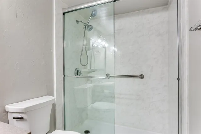 a bathroom with a shower and toilet