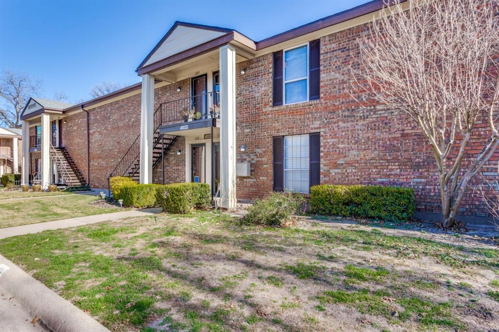 4022 Ridglea Country Club Drive, Unit 608 Fort Worth, TX 76126 - Photo 2 of 28 a view of a brick house with many windows next to a yard