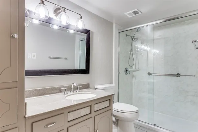 a bathroom with a sink toilet a mirror and shower