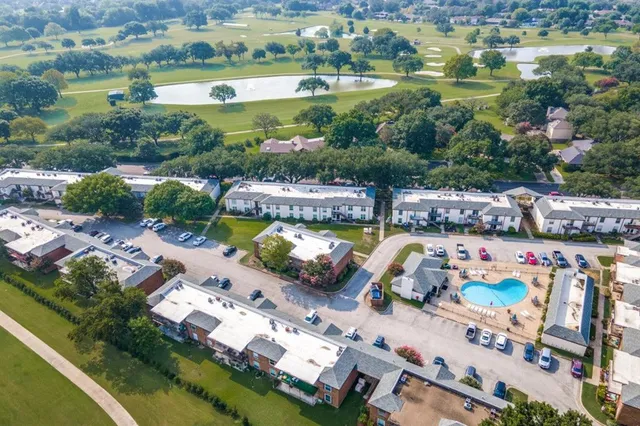 an aerial view of residential houses with outdoor space and lake view