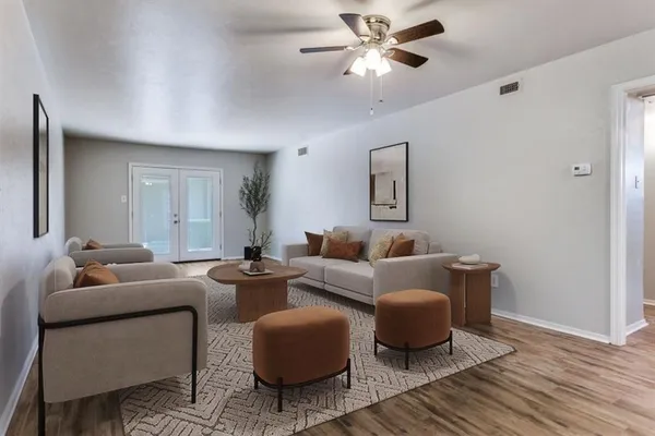 a living room with furniture and a wooden floor