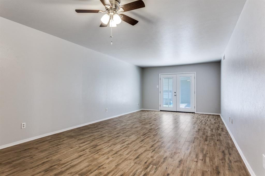 4022 Ridglea Country Club Drive, Unit 608 Fort Worth, TX 76126 - Photo 5 of 28 a view of an empty room with wooden floor and a chandelier fan