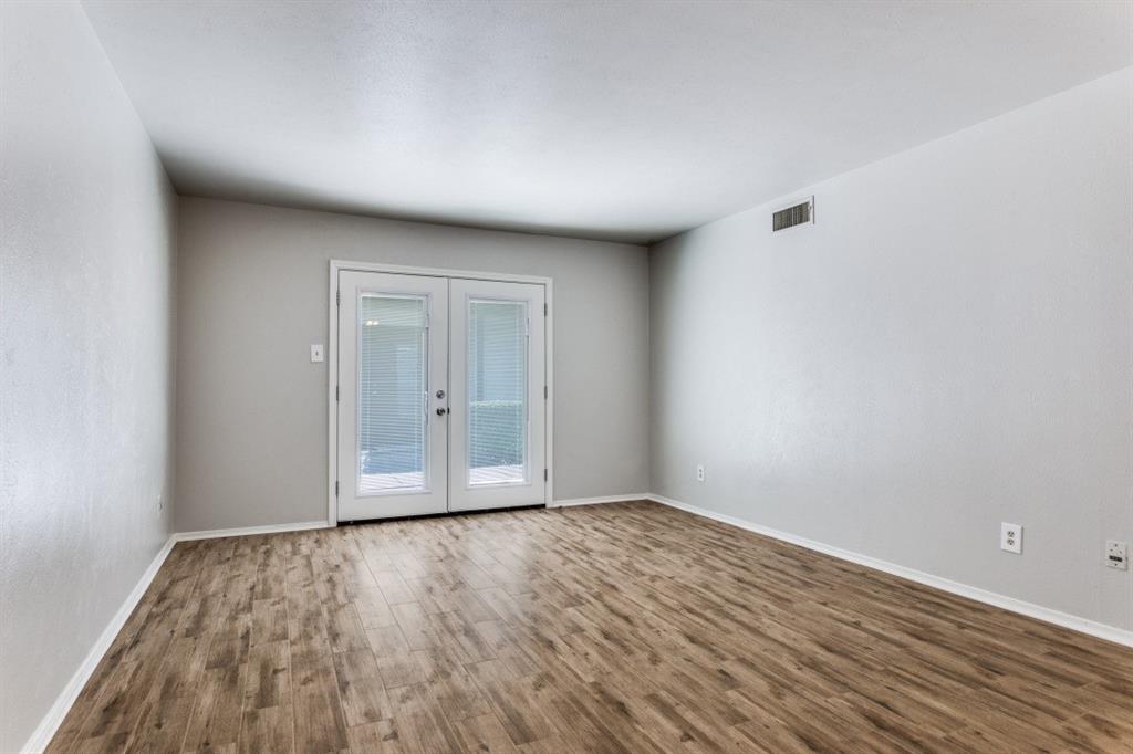 4022 Ridglea Country Club Drive, Unit 608 Fort Worth, TX 76126 - Photo 6 of 28 a view of an empty room with wooden floor and a window