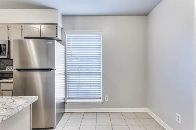 a view of kitchen with a refrigerator cabinets and a window
