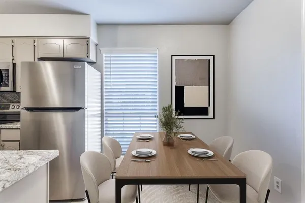 a view of a dining room with furniture and a refrigerator
