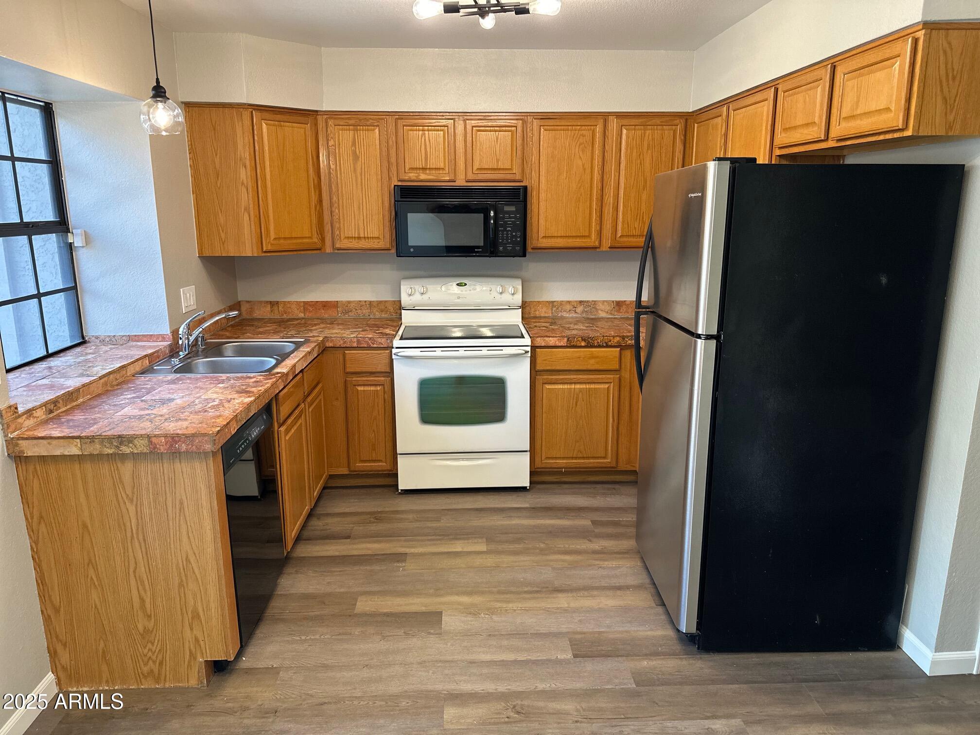 3491 North Arizona Avenue, Unit 20 Chandler, AZ 85225 - Photo 6 of 13 a kitchen with a stove refrigerator and microwave