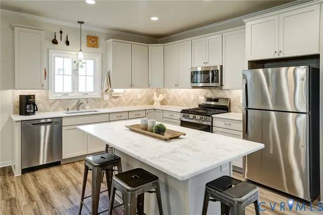 a kitchen with granite countertop a sink stainless steel appliances and white cabinets