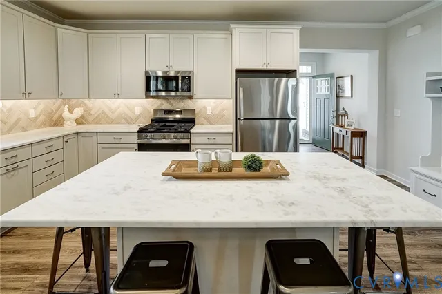 a kitchen with a table chairs refrigerator and cabinets